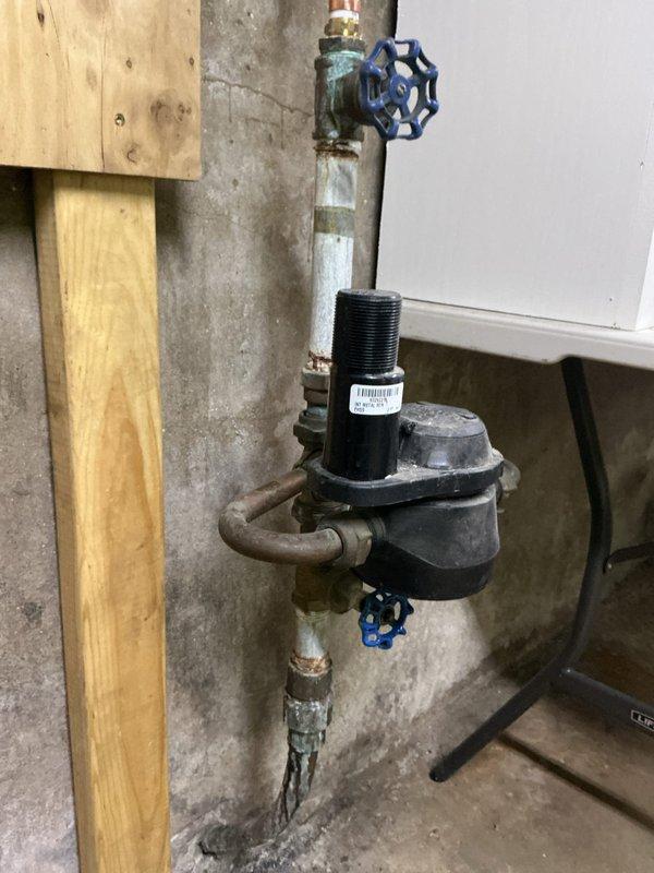 Conducted inspection of pressure regulator valve installation in utility area. Observed significant corrosion and mineral buildup on copper pipes and connections, particularly at valve joints. Identified aging components with visible oxidation requiring future maintenance attention.