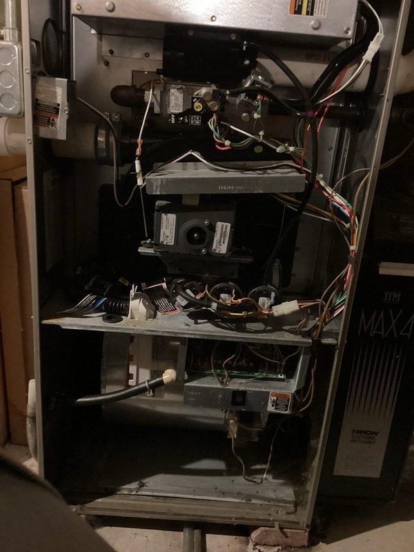 Performed routine tune-up maintenance on gas furnace, inspecting and testing gas valve assembly with proper "HI" settings (confirmed by valve sticker #5). Examined electrical connections, ensuring all wiring harnesses (green, yellow, red, white, and blue) were securely fastened to control board and motor assembly. Cleaned interior components including heat exchanger and verified proper operation of all mechanical elements.