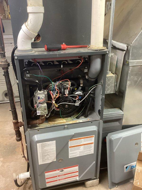 Performed warranty inspection on residential HVAC system. Examined furnace interior components including heat exchanger, burner assembly and control board connections. Verified proper wiring connections to terminals and inspected PVC venting system for proper installation. All components functioning within normal parameters with no operational issues identified.