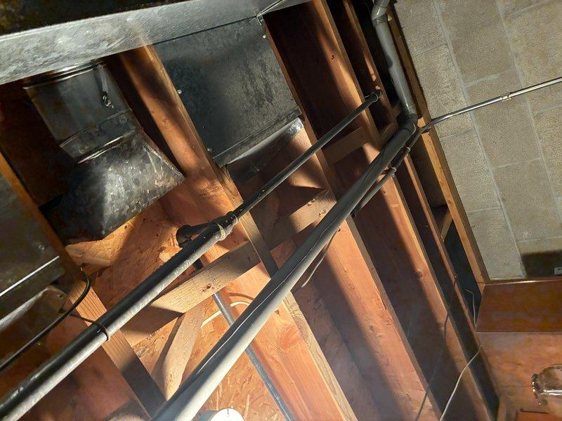 Performed inspection of existing water heater installation. Unit appears to be properly installed with required copper piping connections and pressure relief valve in place. Examined surrounding structural elements including joists and PVC plumbing lines. Water heater is positioned correctly against concrete block wall with all manufacturer labels intact and no visible leaks or damage.