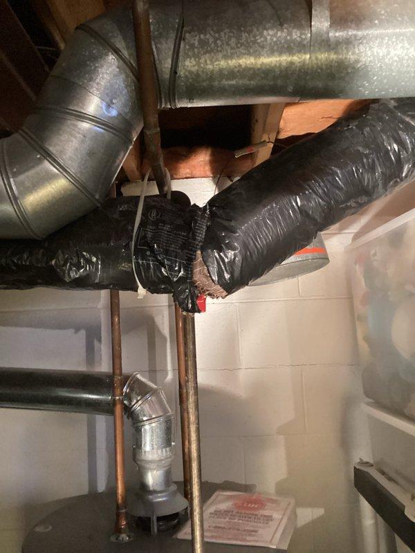 Performed inspection of basement HVAC system, focusing on ductwork configuration. Examined galvanized metal trunk lines, black flexible insulated ducting, and associated PVC drainage components. Verified all connections were properly sealed and insulated with no visible leaks or deterioration. System is functioning as designed with proper airflow throughout.