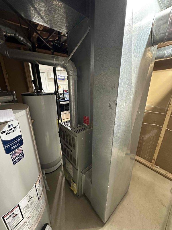 Conducted comprehensive assessment of existing HVAC system located in basement utility room alongside Bradford White water heater. Evaluated current furnace installation, associated ductwork configuration, and available space for replacement unit. Prepared estimate for complete system replacement including proper sizing and connection to existing metal ductwork infrastructure.