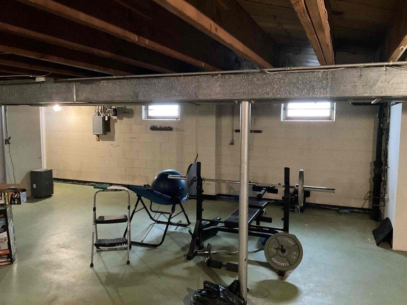 Conducted inspection of existing ductwork system in unfinished basement area. Observed exposed metal ducts running between ceiling joists with visible silver insulation. Evaluated system configuration for potential modifications to accommodate basement repurposing as home gym space while maintaining proper airflow distribution.