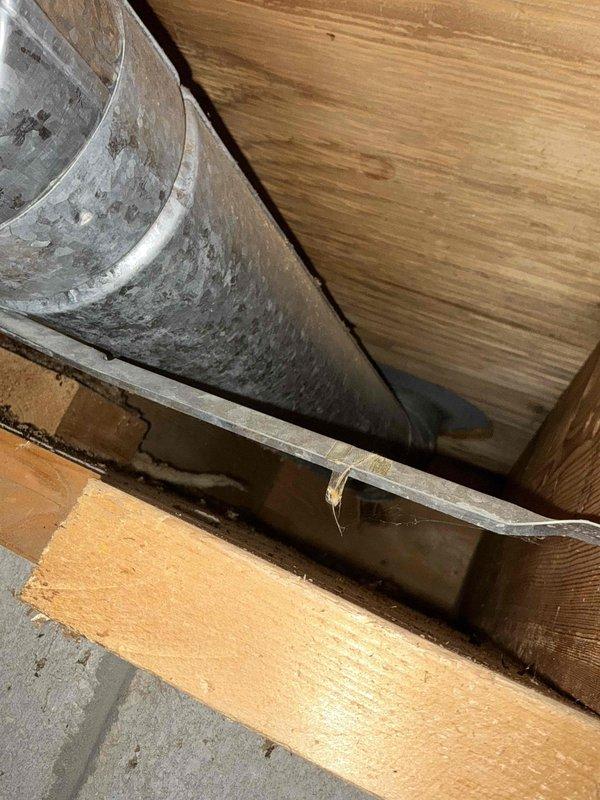 Conducted inspection of existing ductwork system and water heater. Observed aged metal ductwork with significant dust accumulation installed within wooden framing structure. Noted Rheem Professional water heater in functional condition with proper ventilation and supply line connections mounted against concrete block wall in utility area.