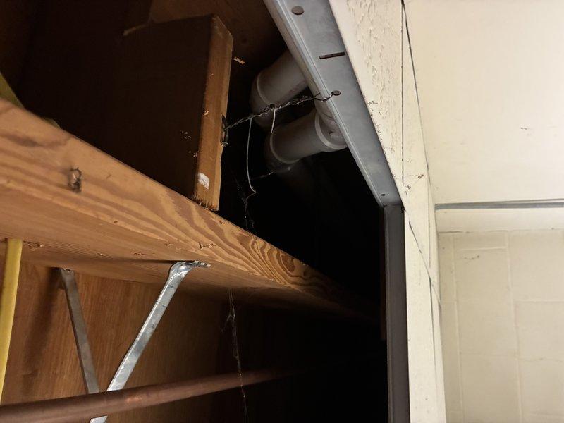 Completed water heater installation in residential utility area with proper copper and PVC plumbing connections. System includes integrated filtration unit mounted above the heater. Inspected adjacent structural areas including joists and existing PVC drainage lines to ensure proper integration with new installation.