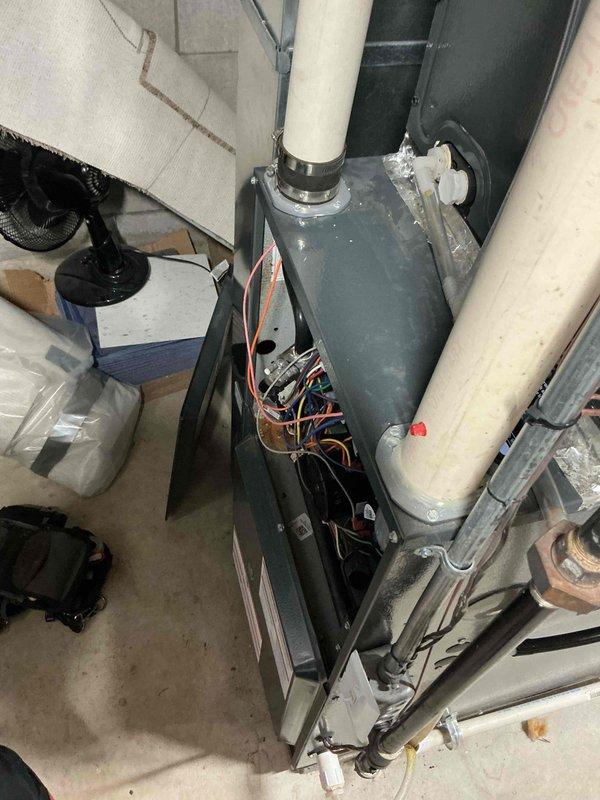 Performed diagnostic inspection on a furnace system with access panel open to check control board wiring connections. Examined PVC venting pipes and confirmed proper mounting of all components. Gloves placed on unit during service indicate hands-on troubleshooting was completed, likely addressing an intermittent operation issue.