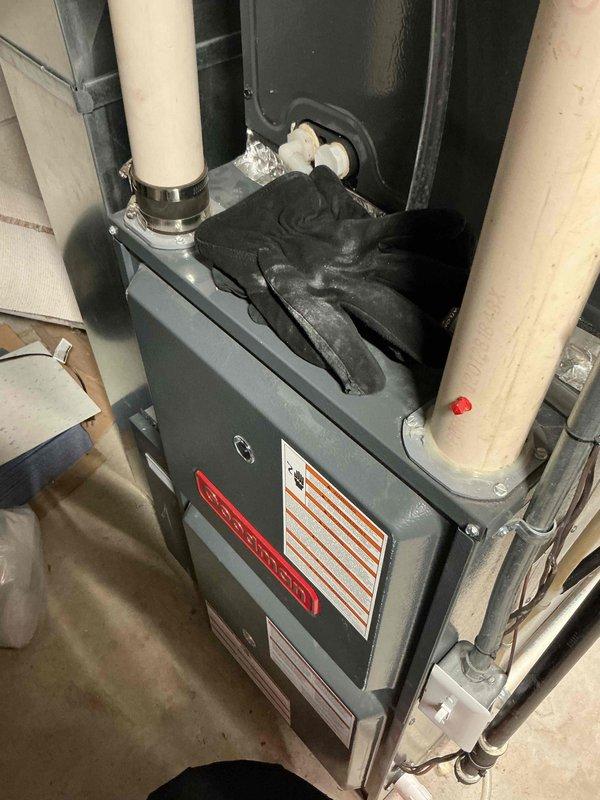 Performed diagnostic inspection on a furnace system with access panel open to check control board wiring connections. Examined PVC venting pipes and confirmed proper mounting of all components. Gloves placed on unit during service indicate hands-on troubleshooting was completed, likely addressing an intermittent operation issue.