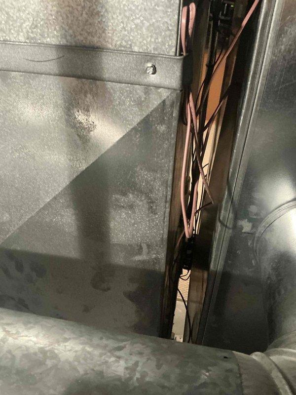 Conducted IAQ assessment on HVAC system, focusing on electrical components and internal ductwork. Identified and documented wiring connections from control interface (red housing unit) to main system. Inspected copper wiring bundle in internal channel for proper routing and potential deterioration. Photos taken of key components for documentation purposes.