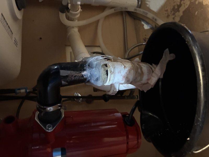 Responded to service call for water leak. Inspected and diagnosed condensation issue at PVC pipe junction where black PVC connects to white PVC piping. Installed new sealing material at the connection point and verified proper operation of the red water pump system with associated drainage components.