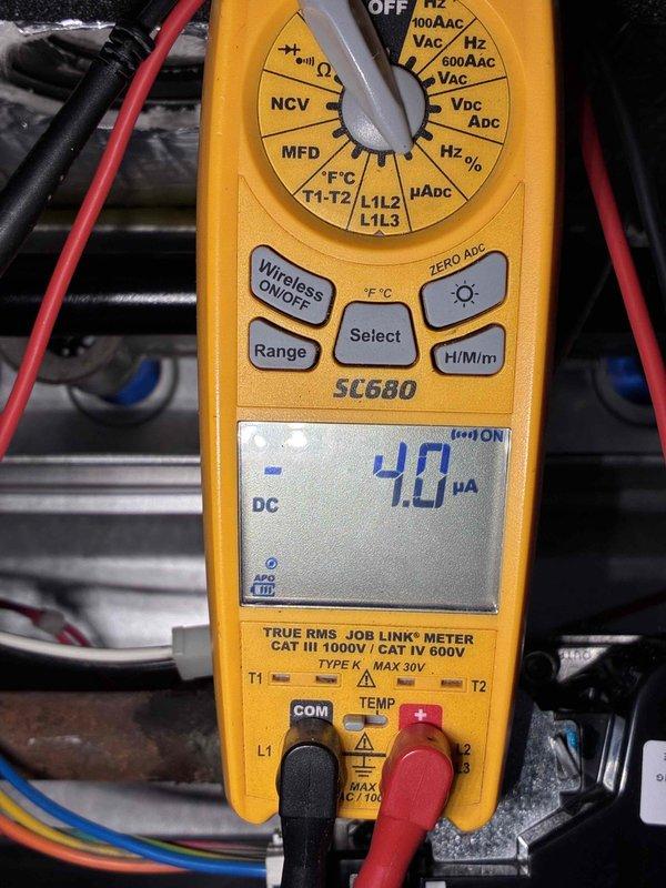 Performed routine tune-up on HVAC system, inspecting electrical connections and securing loose wiring with cable ties. Conducted amperage testing using SC680 multimeter, measuring 4.0 μA DC current draw on control board circuitry to verify proper electrical operation of the unit.