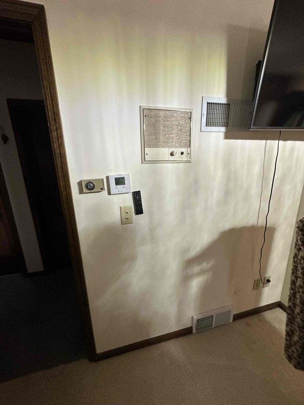 Conducted comprehensive inspection of HVAC system components including examination of wall-mounted thermostat, ventilation outlets, and electrical service panel. Documented existing circuit breaker configuration and evaluated system compatibility for potential replacement. Photos taken of control interfaces and electrical panel for reference in finalizing equipment specifications.