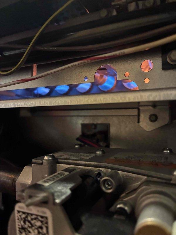 Performed routine tune-up on HVAC system, inspecting internal compartments and verifying proper operation of control board. Observed system functioning correctly with normal indicator light patterns on circuit board, confirming system is operating within specifications.