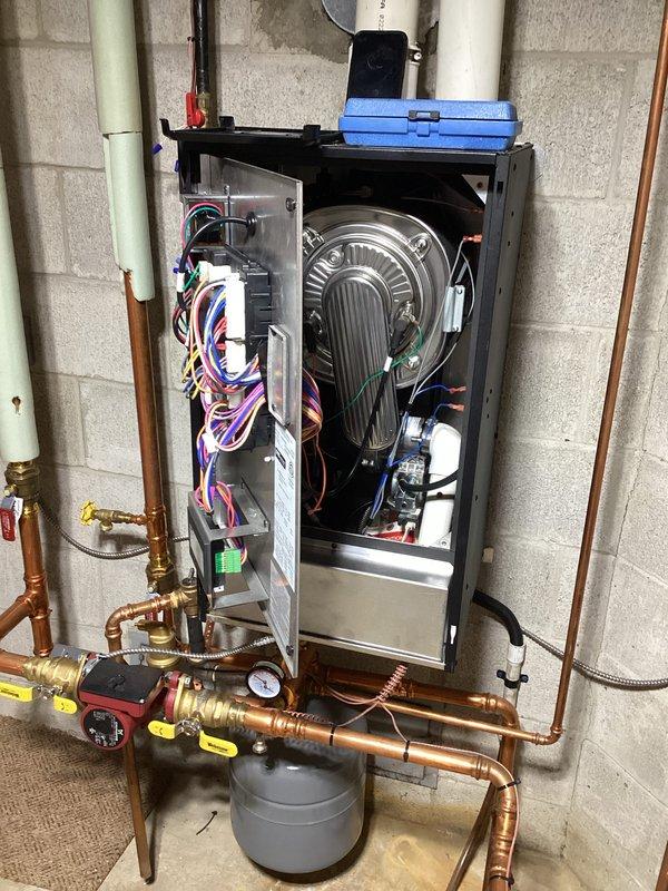 Performed inspection and maintenance service on hydronic boiler system. Accessed internal components including burner assembly, control boards, and circulation system. Verified proper operation of ignition system (observed normal flame pattern) and confirmed all electrical connections were secure with no issues detected in the primary heating elements.