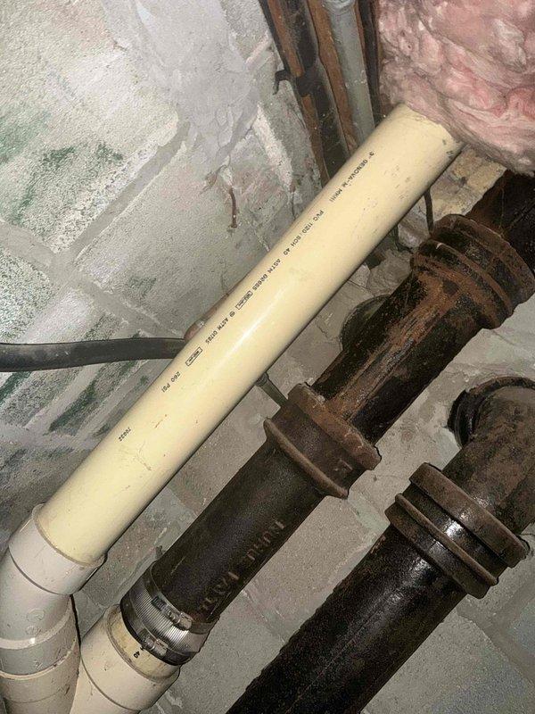 Conducted inspection of existing HVAC system in basement utility room, documenting aging furnace unit with connected ductwork and nearby water heater. Noted significant corrosion on plumbing components, particularly on metal pipes and fittings, with newer PVC sections having been previously installed. Recommended complete system replacement due to visible wear, rust damage, and potential efficiency concerns.