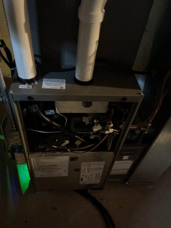 Conducted comprehensive tune-up service on residential HVAC system located in basement utility area. Performed inspection of furnace interior components including control boards, wiring, and copper tubing, ensuring all connections were secure and operational. System was verified to be functioning within normal parameters with proper venting through PVC exhaust pipes.