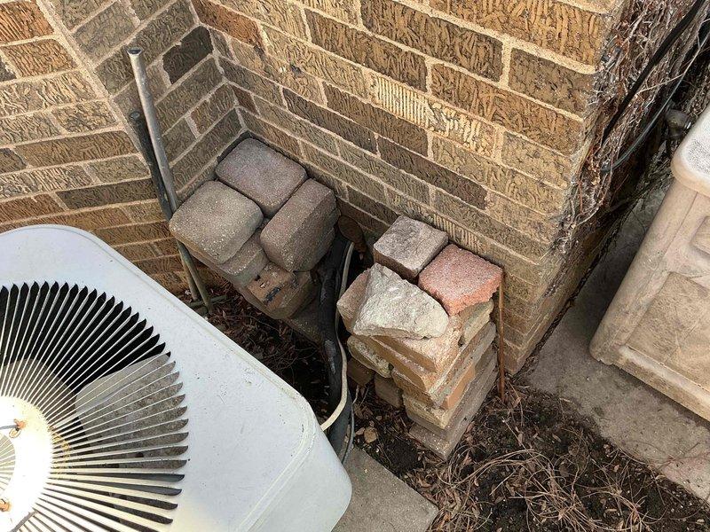 Conducted inspection of existing outdoor HVAC unit installed at brick exterior wall showing signs of age and wear. Documented current installation configuration including electrical connections and refrigerant lines. Provided estimate for complete system replacement including new outdoor condensing unit and indoor air handler with appropriate warning labels and electrical safety components.