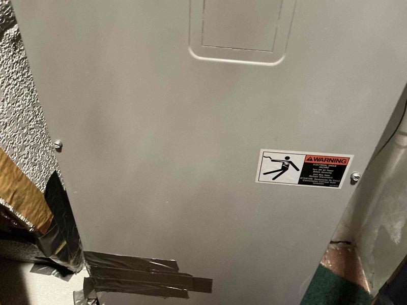 Conducted inspection of existing outdoor HVAC unit installed at brick exterior wall showing signs of age and wear. Documented current installation configuration including electrical connections and refrigerant lines. Provided estimate for complete system replacement including new outdoor condensing unit and indoor air handler with appropriate warning labels and electrical safety components.