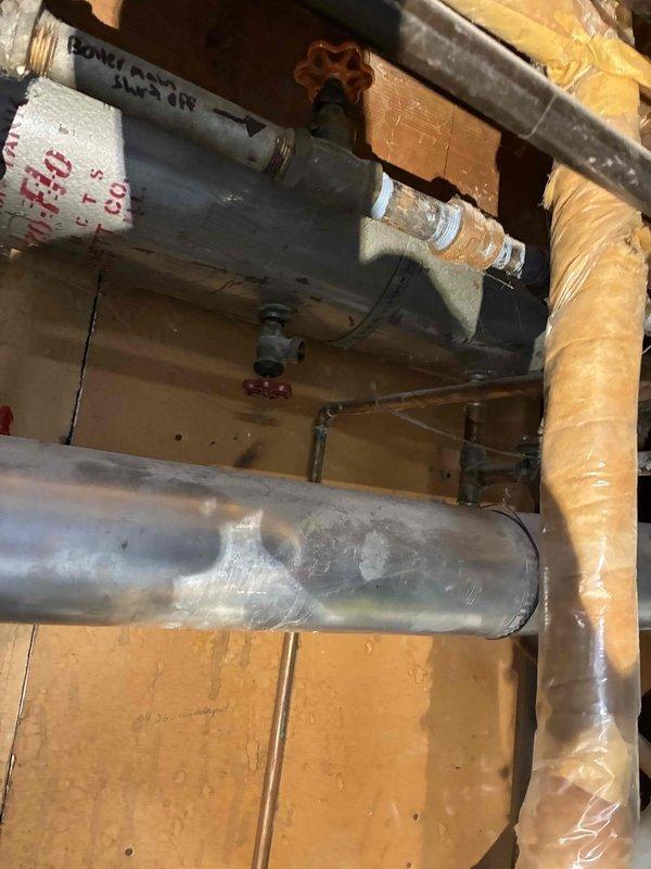 Inspected existing boiler system including horizontal and vertical piping network, insulation condition, and all connected valves. Performed visual assessment of galvanized metal ductwork, copper supply lines, and brass shutoff valve functionality. Verified proper operation of cylindrical heating unit with attached copper pipes of varying diameters, confirming all tagged valves were in correct positions for optimal system performance.