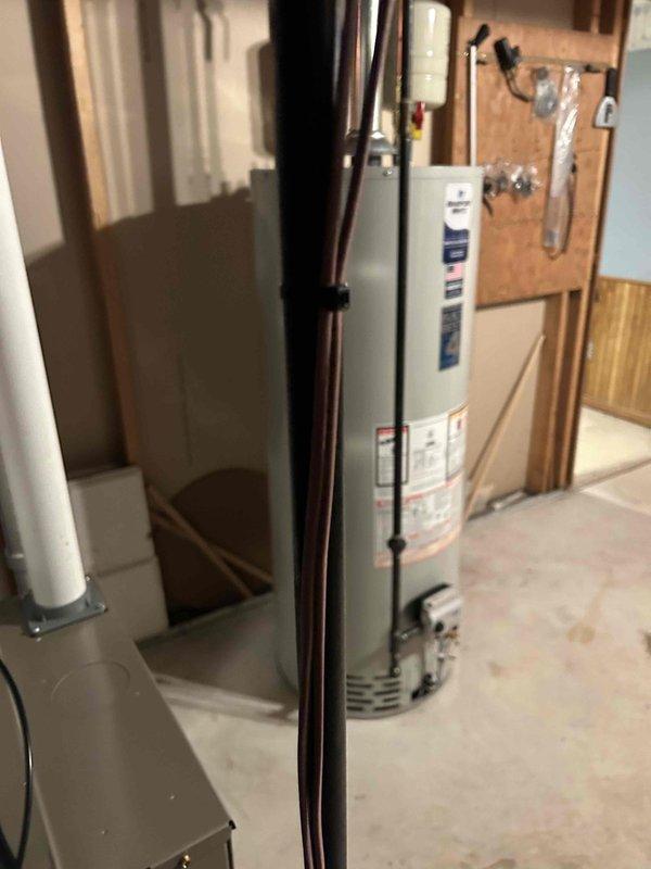 Successfully installed a complete HVAC system with a digital control interface mounted on the wall, providing user-friendly access to multiple evaporator options including models CNPV1917, CNPV2M, CNPV2517, CNPV2514, CIV1814, and CNPV3014. System was properly integrated with the existing water heater and utility infrastructure, with all copper lines neatly bundled and secured for optimal performance and aesthetics.