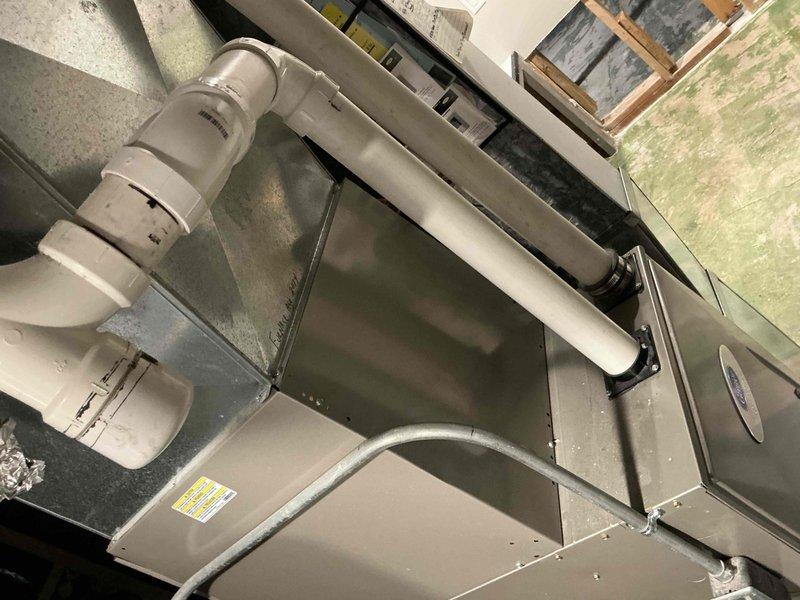 Completed installation of a new air handler/furnace unit with PVC drainage system in utility space. Unit was properly secured with mounting brackets and connected to existing ductwork. All connections were verified and system was tested to ensure proper operation.