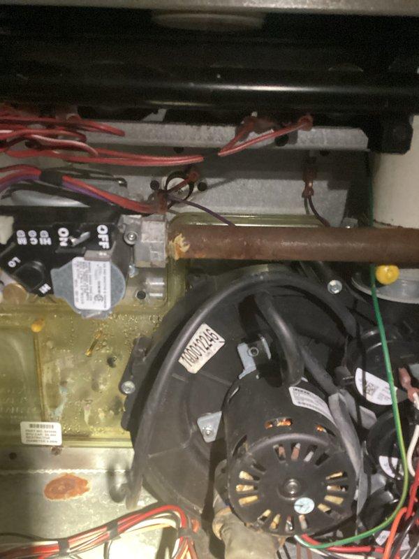 Performed comprehensive tune-up on aging HVAC system located in unfinished basement utility area. Inspected exposed mechanical components including motor assembly, fan housing, and control module, noting oxidation on copper piping and general wear. System remains operational with recommended maintenance schedule established to address aging components.