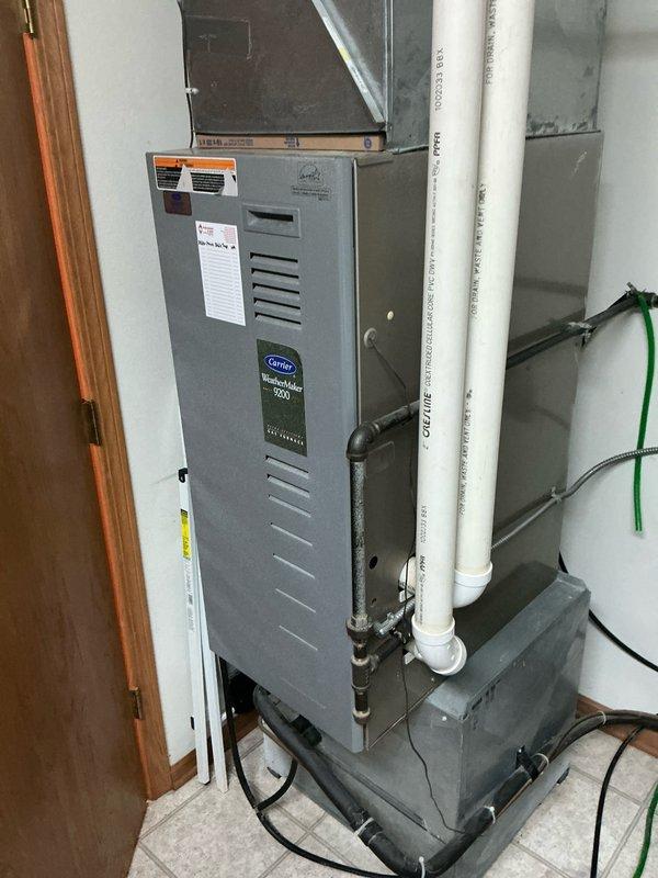 Performed comprehensive evaluation of existing Carrier WeatherMaker 9200 furnace system. Documented current installation configuration including PVC ventilation/drainage components and existing ductwork connections. Prepared detailed replacement estimate for complete HVAC system upgrade based on observed specifications and structural requirements of the utility room installation.
