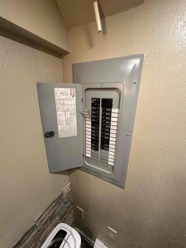 Performed inspection of existing boiler system and electrical panel. Documented current installation showing aging cylindrical water heater/boiler with conical top section connected to complex copper piping network in basement utility area. Electrical service panel appears in good working condition with proper labeling. Noted sump pump system with red motor component installed nearby. Photographs taken of all components to support comprehensive estimate for recommended system upgrades.