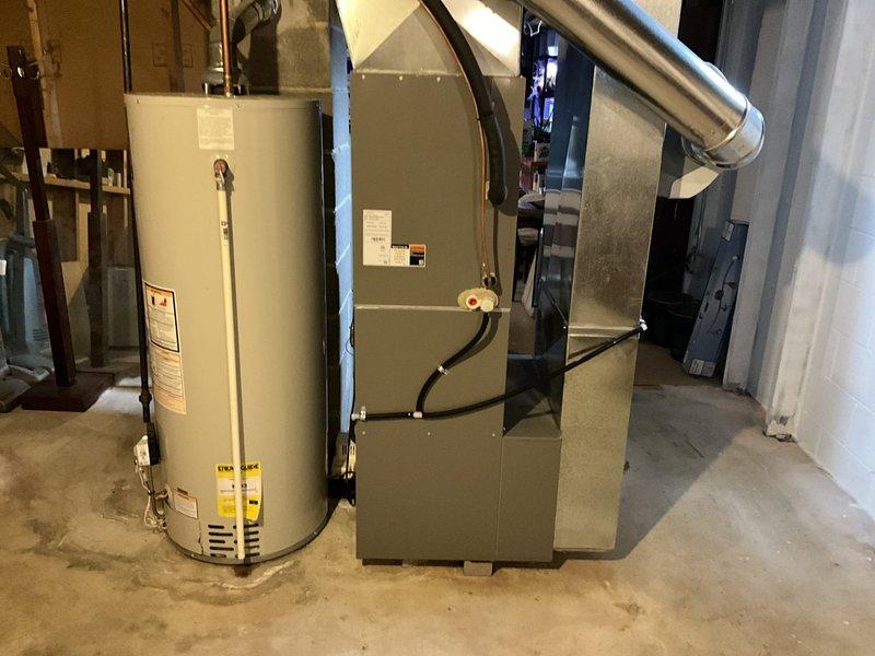 Conducted comprehensive assessment of residential HVAC system and indoor air quality in basement utility area. Inspected gas furnace and water heater installation, noting proper ventilation through existing metal ductwork. Documented storage conditions adjacent to HVAC equipment, identifying potential airflow restrictions and dust accumulation sources that could impact system efficiency and air quality.