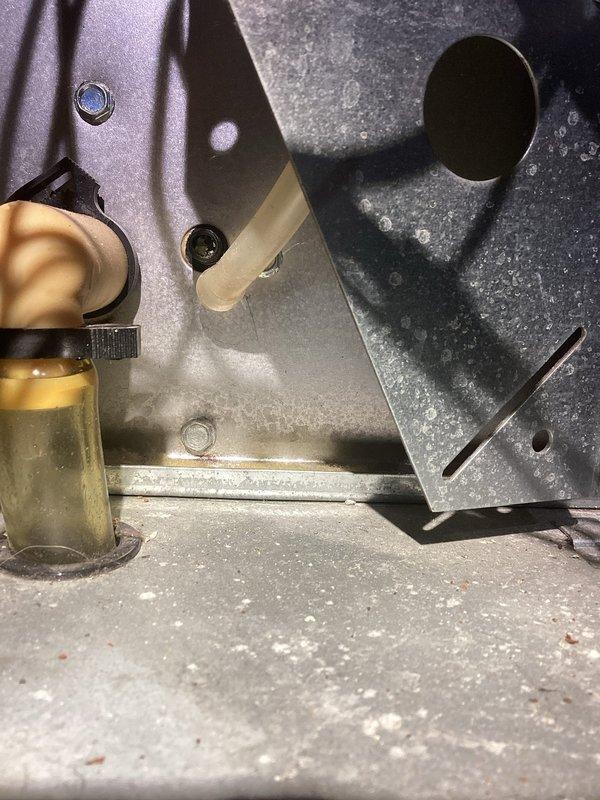 Responded to no heat call for system under 10 years old. Discovered condensate drain assembly with significant corrosion and mineral buildup causing blockage. Replaced damaged condensate trap and cleared drain line, restoring proper system operation and heat function.