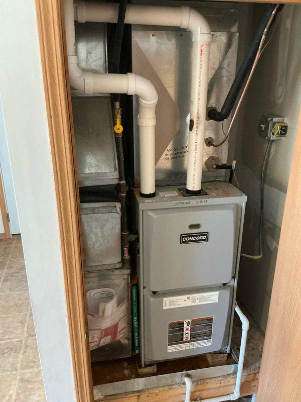 Performed inspection and estimate for replacement of aging Concord furnace system. Current unit shows signs of corrosion on floor beneath unit, suggesting possible water damage or leakage issues. Recommended full replacement of furnace system including upgrading PVC exhaust/intake ventilation components and ensuring proper gas line connection with appropriate safety valve installation.