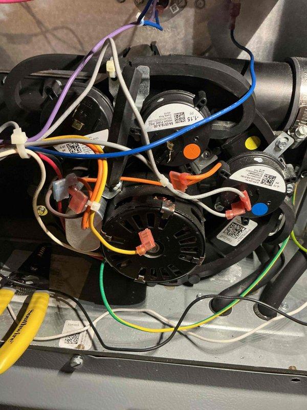 Performed diagnostic inspection of HVAC system, focusing on motor assembly and electrical connections. Examined blower motor components and verified integrity of wiring harness including blue, white, purple, orange, yellow, and green wires. Confirmed proper operation of pressure switches and sensors with all connections secure and properly routed.