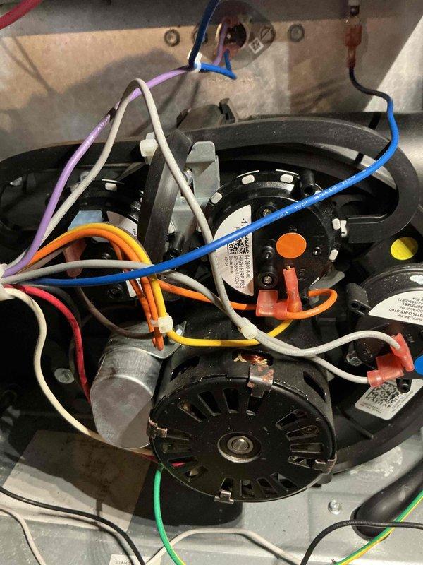 Performed diagnostic inspection of HVAC system, focusing on motor assembly and electrical connections. Examined blower motor components and verified integrity of wiring harness including blue, white, purple, orange, yellow, and green wires. Confirmed proper operation of pressure switches and sensors with all connections secure and properly routed.