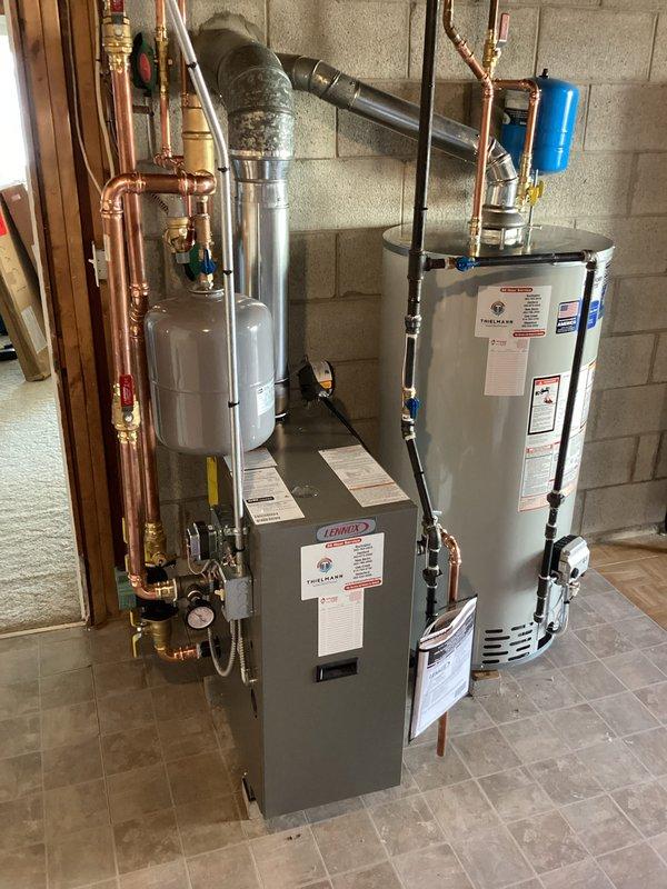 Completed installation of a Lennox boiler system with integrated hot water tank in residential mechanical room. Installation included proper mounting of expansion tank, pressure tank, and connection of all copper supply/return lines with brass fittings. All components were tested and verified to be in good working condition with no leaks detected.