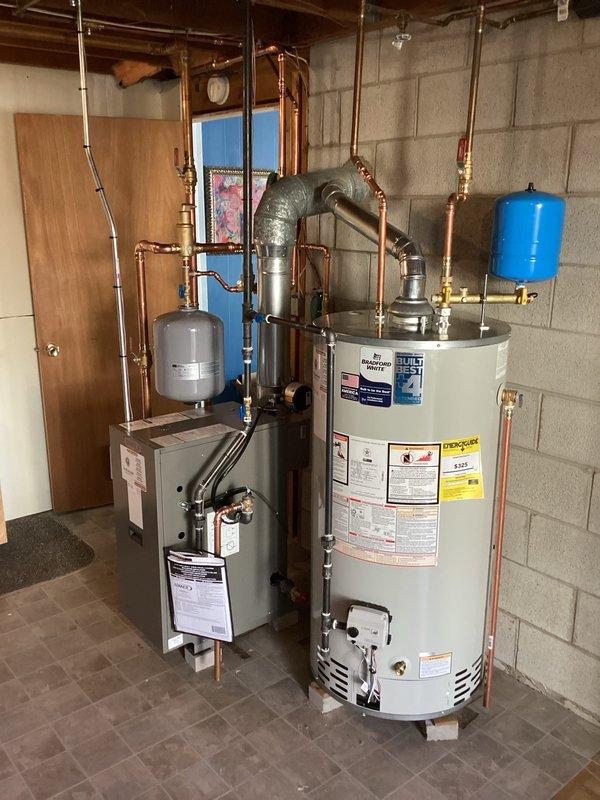Completed installation of a Lennox boiler system with integrated hot water tank in residential mechanical room. Installation included proper mounting of expansion tank, pressure tank, and connection of all copper supply/return lines with brass fittings. All components were tested and verified to be in good working condition with no leaks detected.