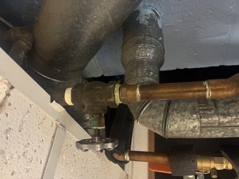 Inspected copper water supply lines and galvanized ventilation system connected to tanked water heater. Identified minor corrosion at brass fitting connection points on copper piping. Verified proper installation of ventilation ductwork and confirmed all components were functioning properly despite some normal oxidation.