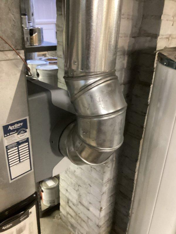Performed inspection of basement mechanical room HVAC system, focusing on ductwork integrity and connections. Examined Aprilaire component installation and verified proper mounting of ventilation unit. Confirmed electrical connections with wire caps were secure and properly terminated on the auxiliary ventilation component.