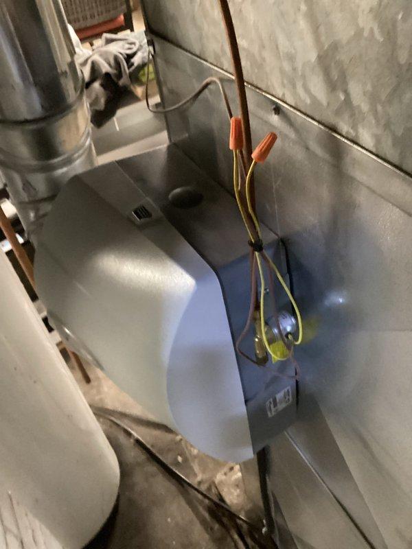 Performed inspection of basement mechanical room HVAC system, focusing on ductwork integrity and connections. Examined Aprilaire component installation and verified proper mounting of ventilation unit. Confirmed electrical connections with wire caps were secure and properly terminated on the auxiliary ventilation component.