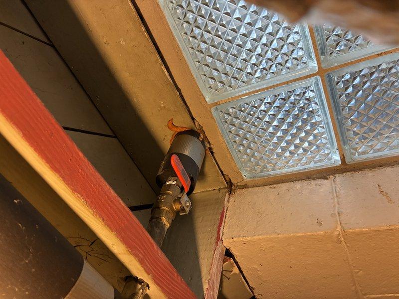 Performed inspection of under-sink plumbing assembly, including PVC pipes, braided supply lines, and accordion-style drain pipe. Examined valve installation with visible wall penetration issues in utility area. Documented condition of plumbing components and identified potential maintenance needs for future service.