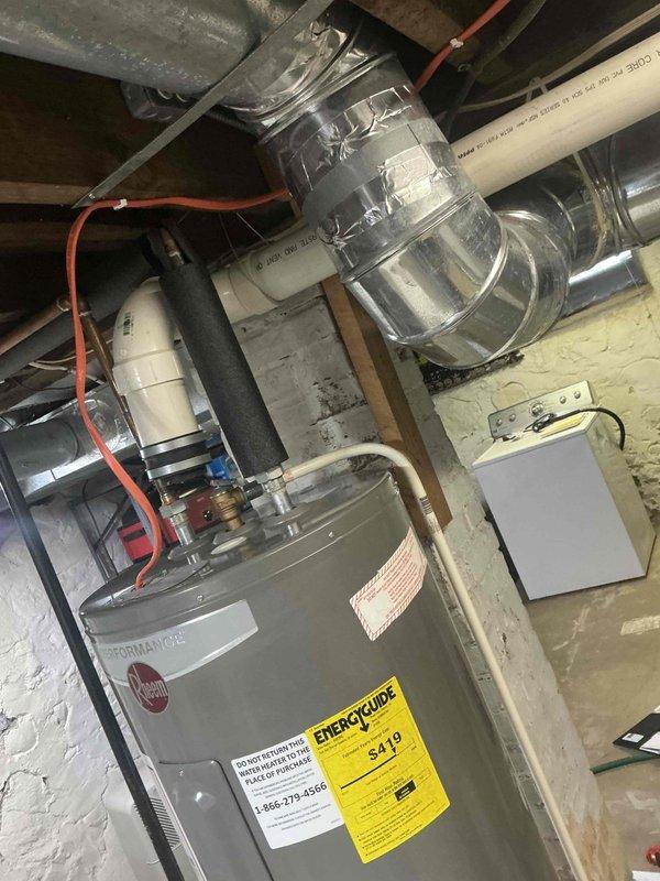 Performed a comprehensive inspection and documentation of existing mechanical systems in the basement utility area, focusing on a Rheem water heater installation with associated PVC venting and metallic ductwork. Examined the crawlspace for structural integrity and utility routing, noting the condition of concrete surfaces, wooden floor joists, and existing plumbing pathways for replacement planning purposes.