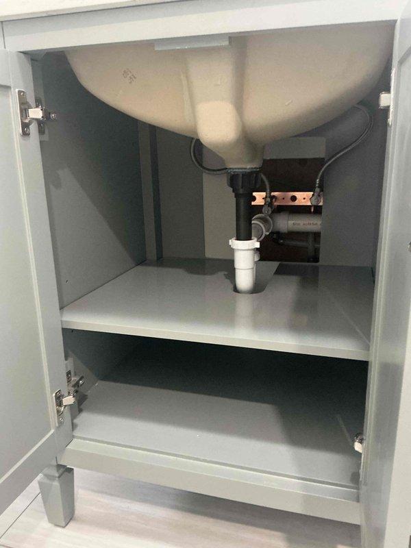 Completed installation of new bathroom vanity with integrated sink and faucet. Connected supply lines and drain assembly with PVC trap. Ensured proper alignment and verified no leaks after installation.