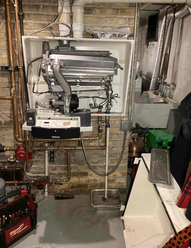 Performed diagnostic inspection of wall-mounted boiler system in utility room, examining heat exchangers, electrical connections, and control panel functionality. Checked all plumbing connections, including copper supply lines and PVC drainage pipes, ensuring proper installation and operation of the heating system. Verified proper venting through flexible metallic ductwork and confirmed system was operating within manufacturer specifications.