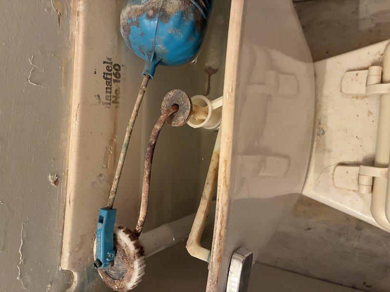 Conducted comprehensive toilet inspection revealing significant issues: toilet base shows poor sealing with accumulated grime and possible water damage to surrounding flooring, while tank inspection revealed an aging flush mechanism with extensive corrosion, mineral buildup, and potential porcelain crazing that may affect proper function and water efficiency.