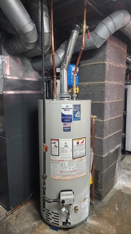 Successfully installed a new water heater system with proper copper supply line connections and galvanized metal ventilation ductwork. Mounted expansion tank on adjacent wall and installed all required valves and fittings to ensure code-compliant operation.