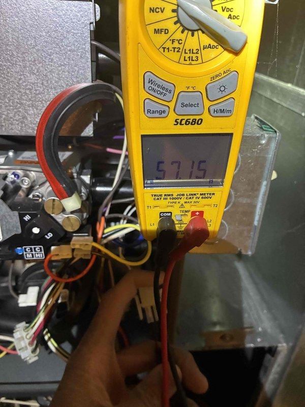 Performed routine maintenance on gas furnace system. Conducted electrical diagnostics with multimeter showing 57.15V reading across control board components. Verified proper flame characteristics with strong blue flame pattern indicating complete combustion and correct gas-air mixture.