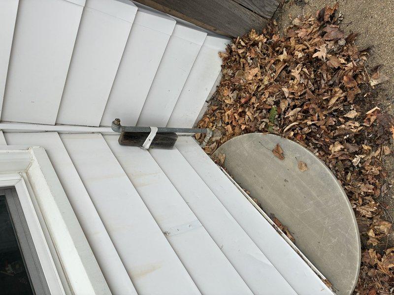 Conducted inspection of residential property to provide piping estimate, documenting exterior access point via wooden deck stairs and examining interior wall cavity. Identified existing plumbing infrastructure with horizontal pipe runs through wooden framing members and assessed insulation condition surrounding piping system for potential replacement or modification work.