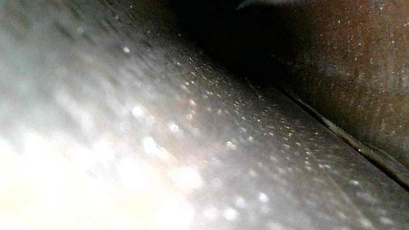 Performed interior duct inspection, revealing accumulated dust and residue buildup within the spiral-wound ductwork. Documented evidence of corrosion and possible moisture issues as indicated by surface discoloration and condensation on metal surfaces.