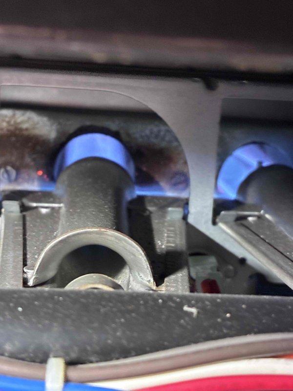 Performed routine inspection of gas furnace with verification of proper flame characteristics and combustion (blue flames observed in burner assembly indicating correct operation). Identified and documented water damage to wooden structural support beam near the furnace/ductwork that requires attention to prevent potential system issues.