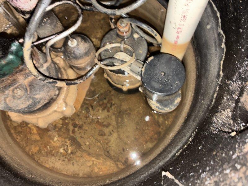 Replaced corroded sump pump system in basement utility area, removing old unit with accumulated sediment and debris from basin. Installed new blue pump unit with complete PVC discharge piping assembly including necessary valves and connectors, and established proper electrical connections to ensure reliable water removal functionality.