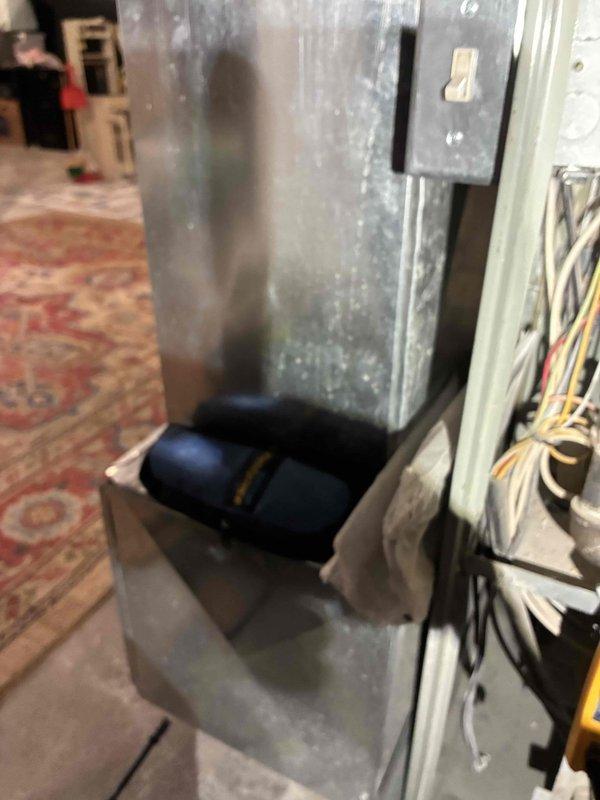 Responded to no-heat service call on aging HVAC system (10+ years). Inspected ductwork connections and identified significant dust accumulation in the main unit. Removed and replaced damaged blower motor assembly (blue cylindrical component) and rewired electrical connections to restore proper heating function.