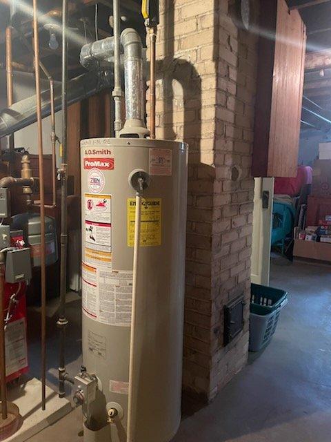 Conducted inspection of existing A.O. Smith ProMax water heater installation in basement utility area. Unit appears properly installed with appropriate ventilation piping and copper supply lines connected to household plumbing system. Verified installation meets code requirements with proper clearances and connections to existing infrastructure.